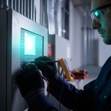 Engineer checking fire alarm panel during maintenance visit