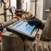 Service technician recording maintenance findings on tablet